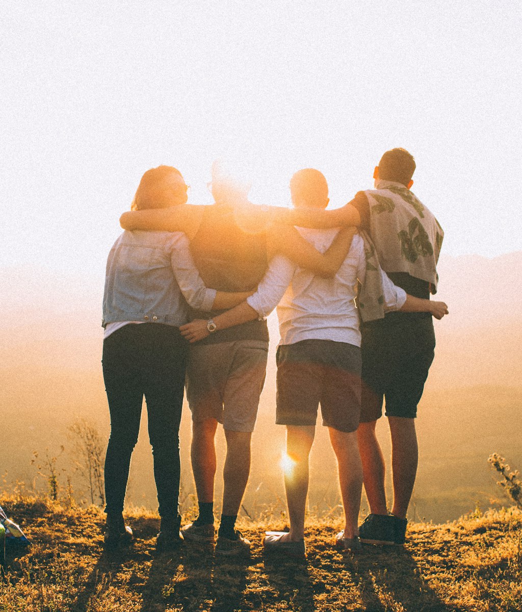 Vier soloreizigers, mannen en vrouwen, die elkaar via Mijn Reismaatje vonden en samen naar de zonsondergang kijken